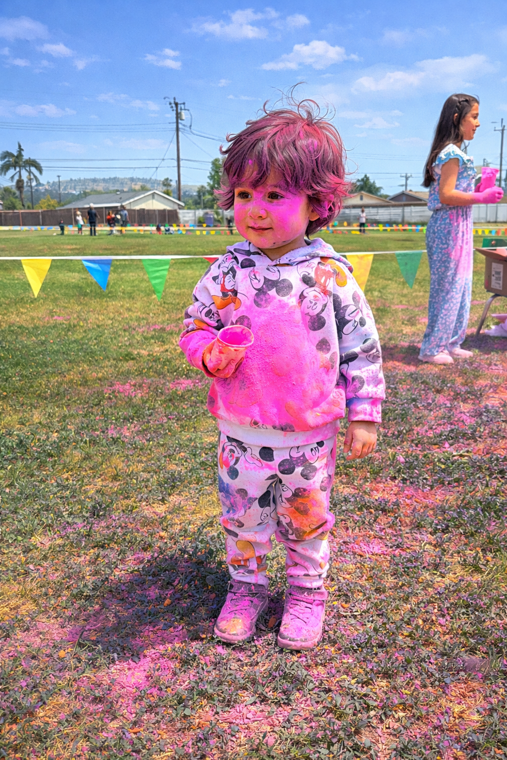 Little kid covered in pink powder